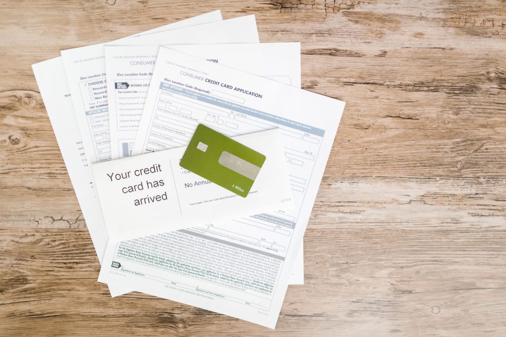 Formulaires de demande et carte bancaire posés sur un bureau